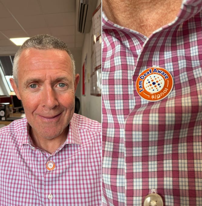 Chris wearing deaf aware badge after our learning session delivered by Signal.